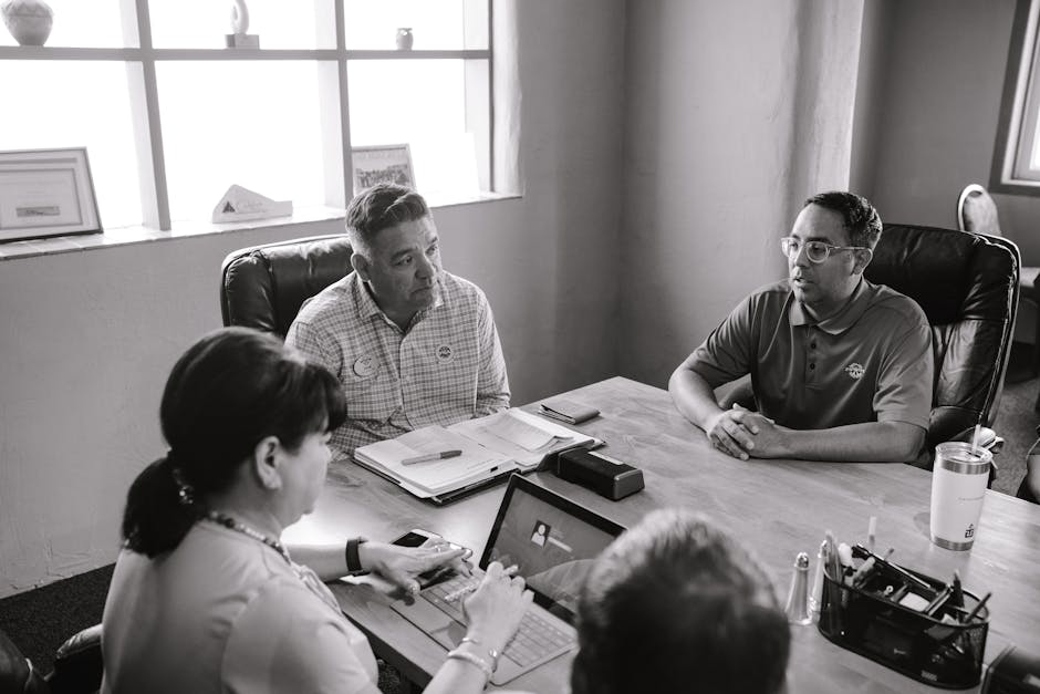 Professional business meeting with diverse colleagues collaborating at a table indoors.